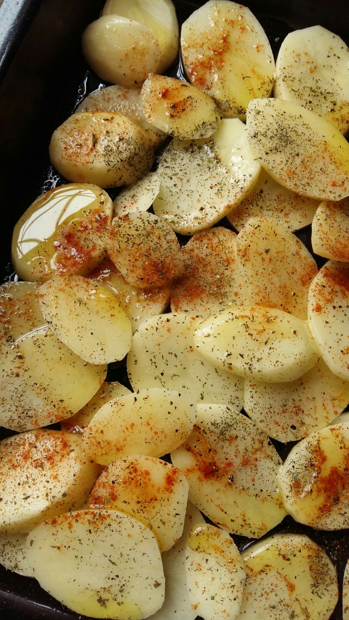 First layer: sliced potatoes seasoned with smoked paprika, dried mint, generous amounts of olive oil, salt and pepper